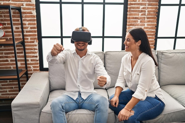 Photo gratuite couple homme et femme jouant à un jeu vidéo à l'aide de lunettes vr à la maison