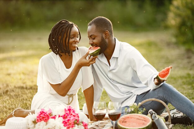 Couple insouciant et détendu profitant du pique-nique ensemble. Ils mangent de la pastèque.