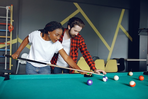 Couple international jouant au billard dans un club