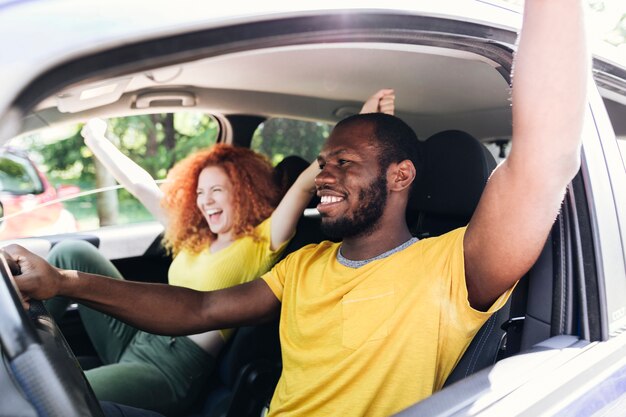 Couple interracial s'amuser lors d'un voyage en voiture