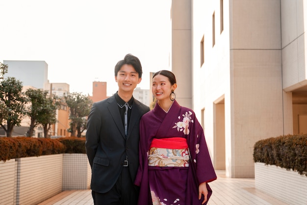 Photo gratuite couple japonais célébrant le jour de la majorité et posant à l'extérieur de la ville