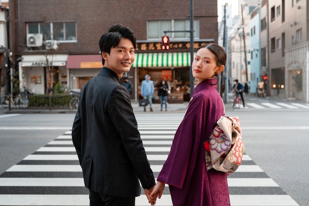 Photo gratuite couple japonais célébrant le jour de la majorité et posant à l'extérieur de la ville