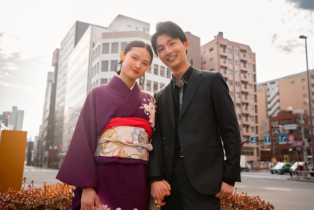 Photo gratuite couple japonais posant à l'extérieur et célébrant le jour de la majorité