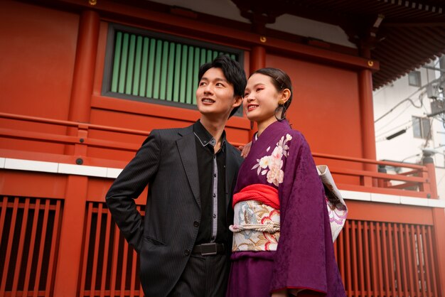 Couple japonais posant à l'extérieur et célébrant le jour de la majorité