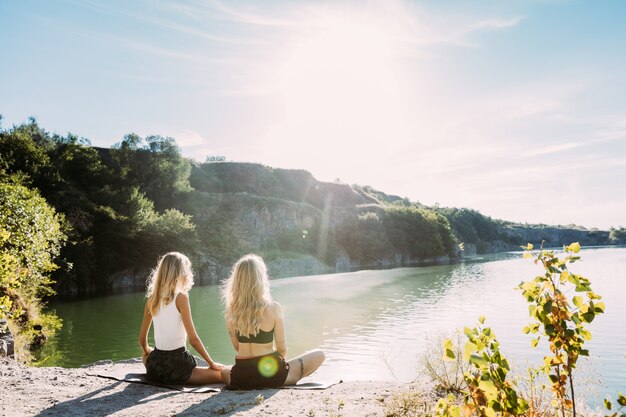 Couple de jeunes lesbiennes s'amusant au bord de la rivière en journée ensoleillée