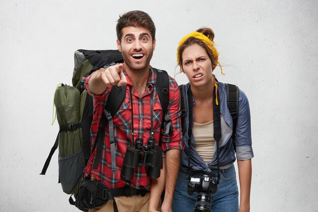 Couple de jeunes touristes avec équipement