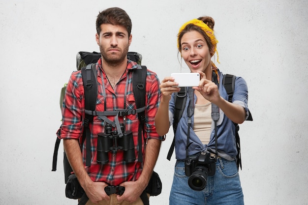 Couple de jeunes touristes avec équipement