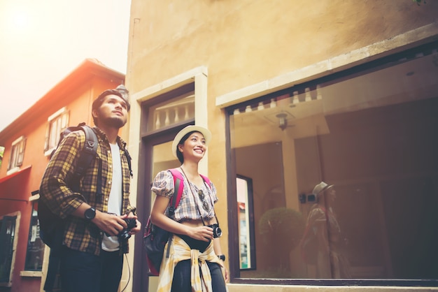 Photo gratuite couple de jeunes touristes marchant en zone urbaine passer des vacances ensemble. concept de voyage de couple.