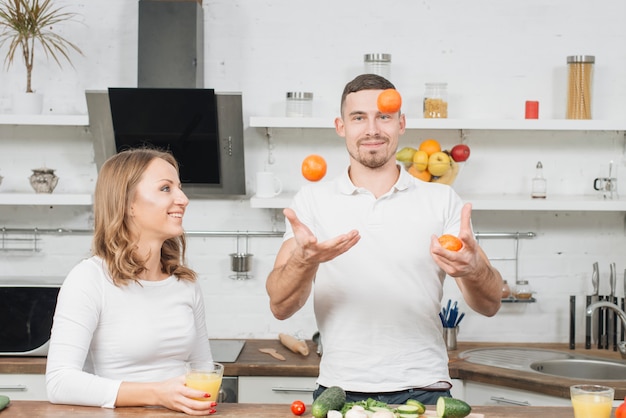 Couple jonglant avec des fruits