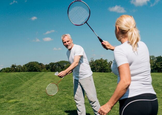 Couple jouant au tennis ensemble à l'extérieur