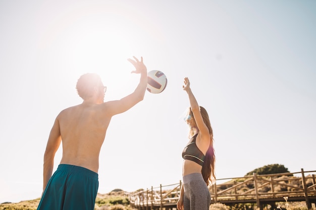 Photo gratuite couple jouant au volleyball à la plage