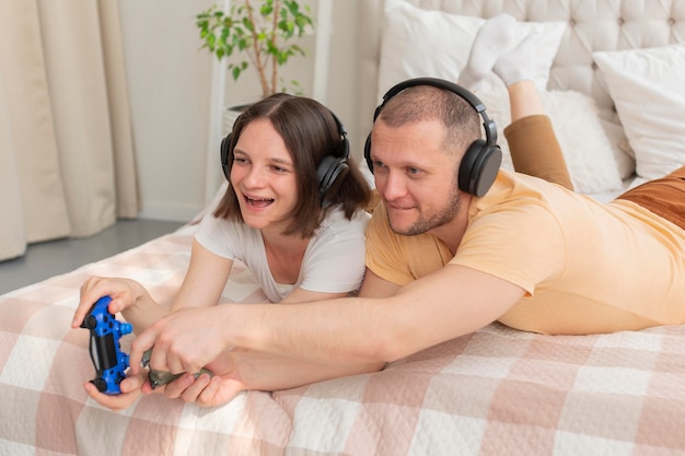 Photo gratuite couple jouant ensemble à des jeux vidéo à la maison