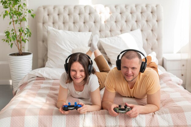 Photo gratuite couple jouant ensemble à des jeux vidéo à la maison