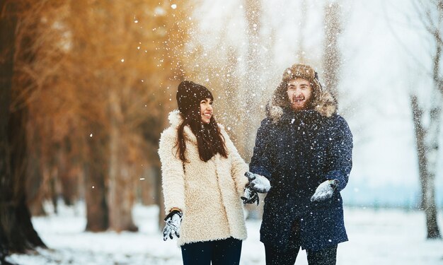 Couple de jouer avec la neige