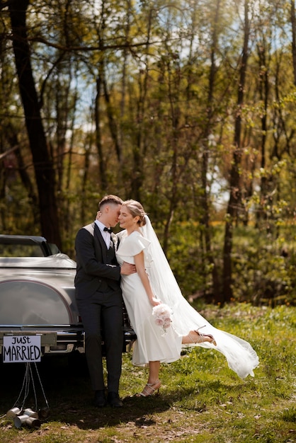 Couple juste marié avec leur voiture