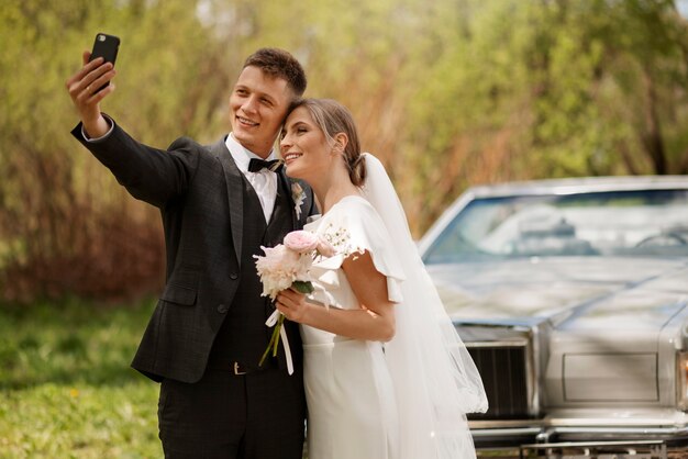 Couple juste marié avec leur voiture