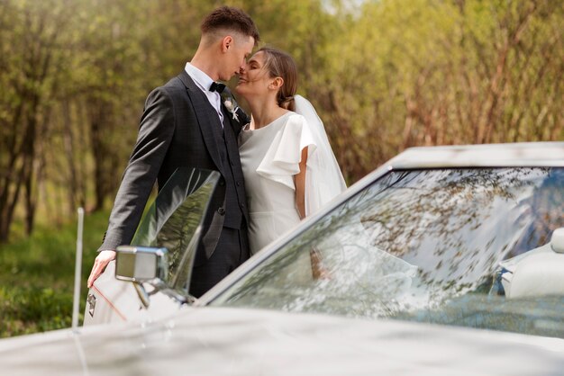 Couple juste marié avec leur voiture