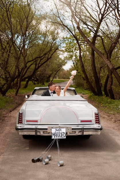 Photo gratuite couple juste marié avec leur voiture