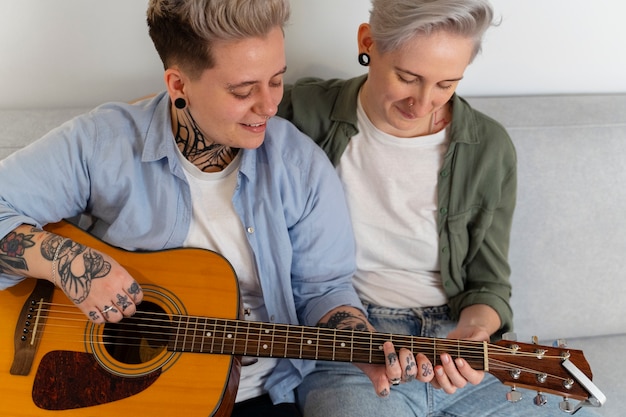 Couple lesbien romantique à angle élevé avec guitare