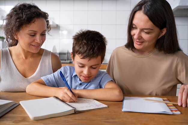 Couple de lesbiennes aidant leur fils à faire ses devoirs