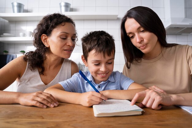 Couple de lesbiennes aidant leur fils à faire ses devoirs