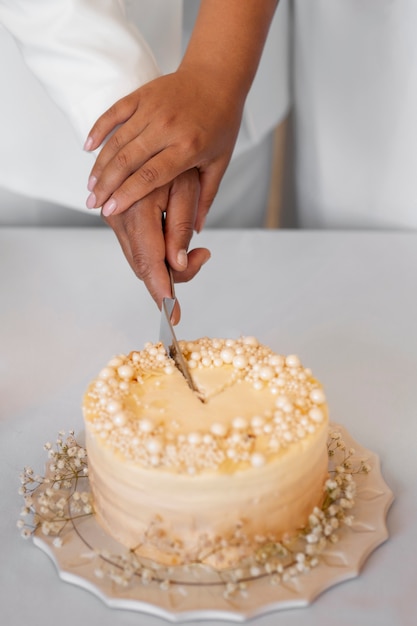 Photo gratuite couple de lesbiennes coupant le gâteau à leur mariage