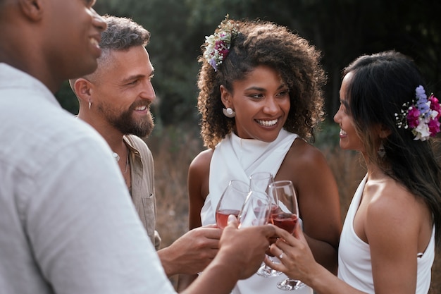 Photo gratuite un couple de lesbiennes fête leur mariage avec des invités et des amis.