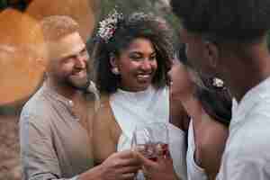 Photo gratuite un couple de lesbiennes fête leur mariage avec des invités et des amis.