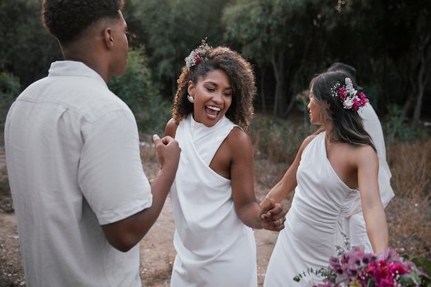 Photo gratuite un couple de lesbiennes fête leur mariage avec des invités et des amis.