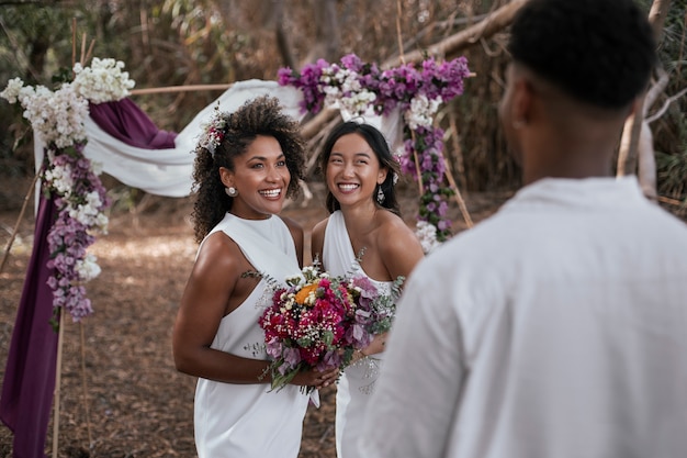 Photo gratuite un couple de lesbiennes fête leur mariage avec des invités et des amis.