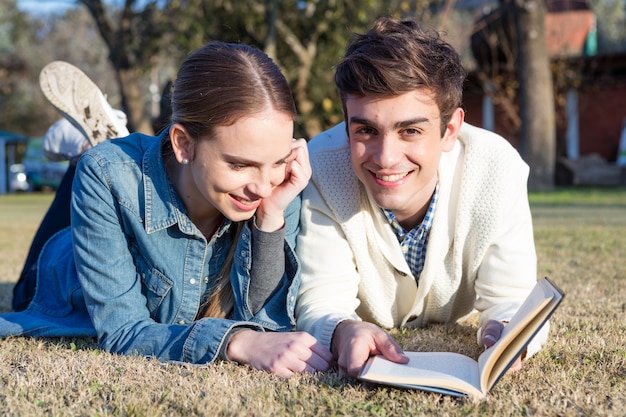 Photo gratuite couple de lire un livre en plein air