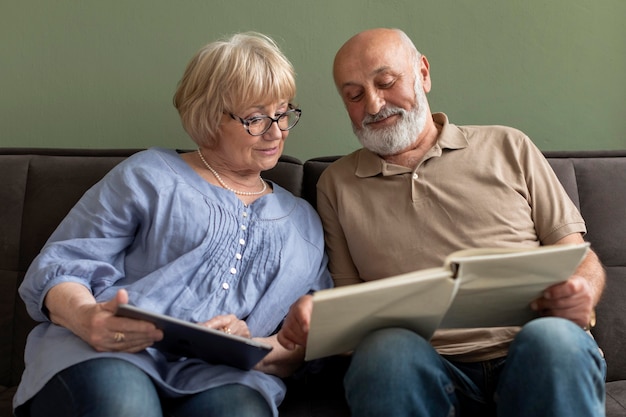 Couple avec livre et tablette à l'intérieur