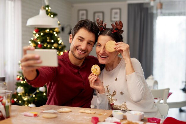 Couple ludique faisant un selfie à Noël