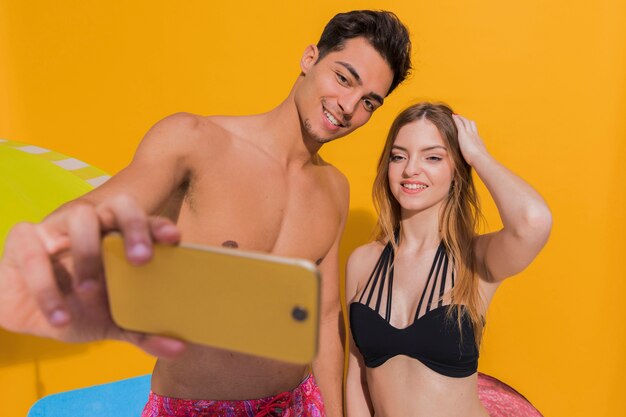 Couple en maillot de bain prenant des photos