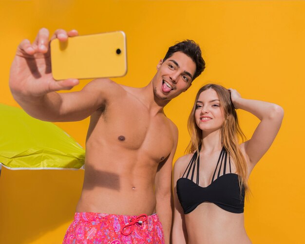 Couple en maillot de bain prenant selfie