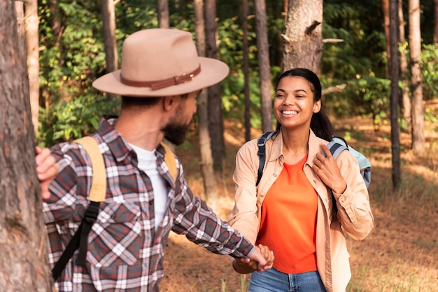 Photo gratuite couple main dans la main en marchant dans une forêt