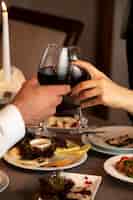 Photo gratuite couple, mains, applaudir, verres vin rouge, à, dîner