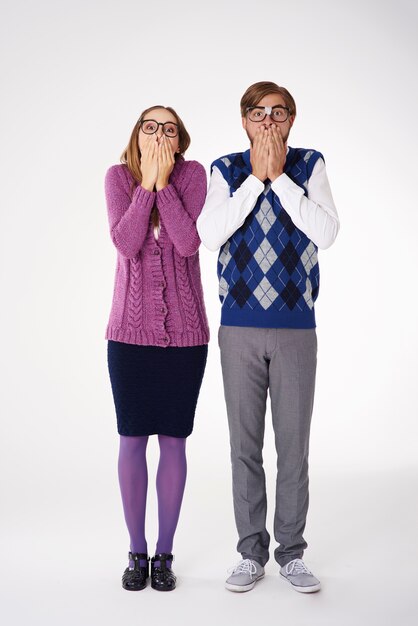 Couple avec les mains couvrant leur bouche isolé