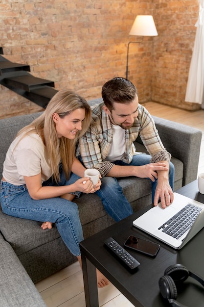 Couple à la maison ayant un appel vidéo avec la famille