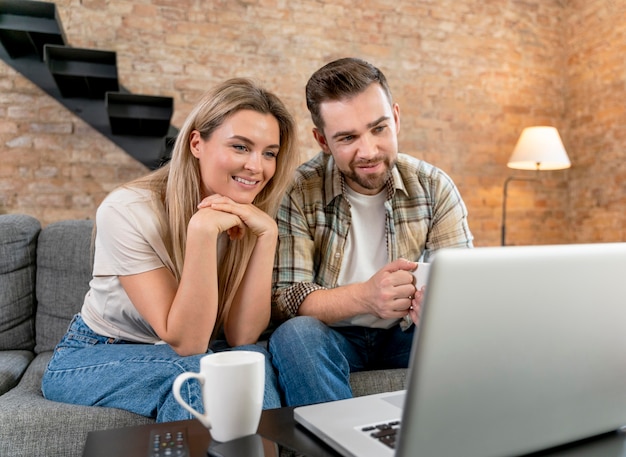 Photo gratuite couple à la maison ayant un appel vidéo avec la famille