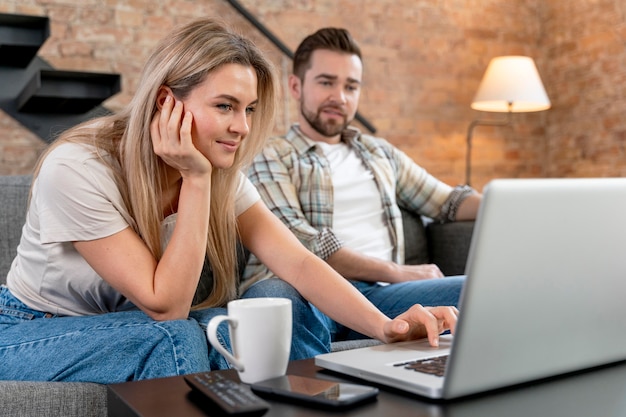 Couple à la maison ayant un appel vidéo avec la famille