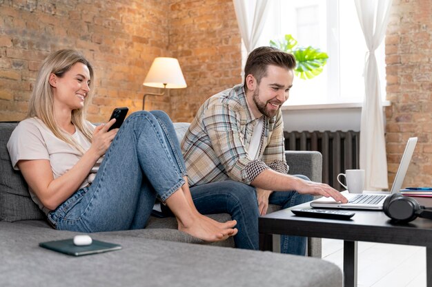 Couple à la maison ayant un appel vidéo avec la famille