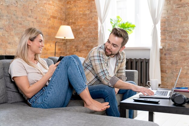 Couple à la maison ayant un appel vidéo avec la famille
