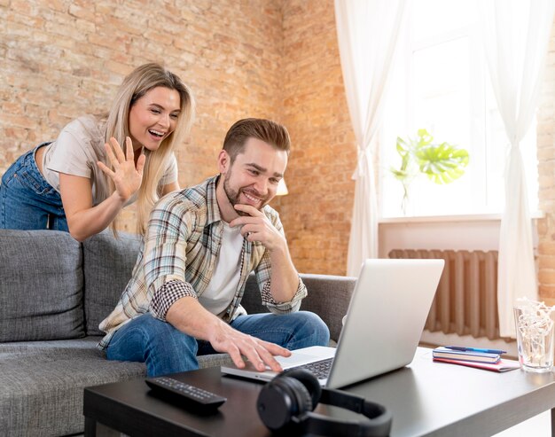 Couple à la maison ayant un appel vidéo avec la famille