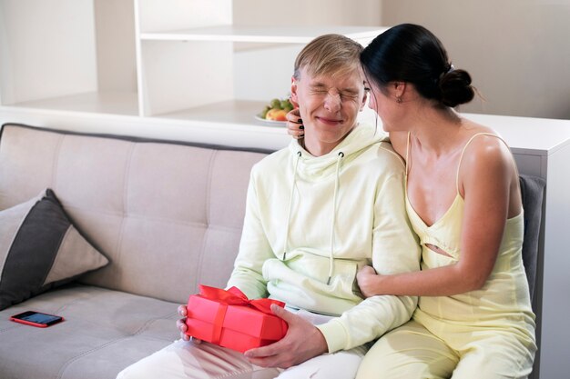 Couple à la maison célébrant la saint valentin avec boîte-cadeau