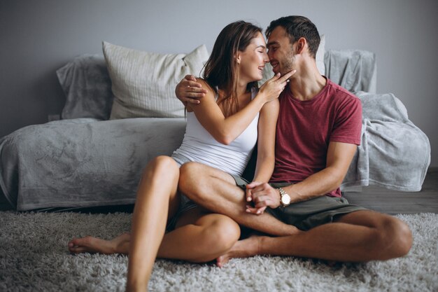 Couple à la maison ensemble assis sur le sol près du canapé