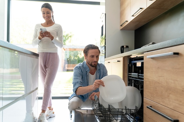 Couple à la maison faisant des tâches ménagères