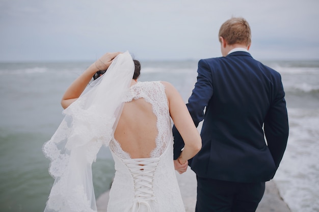 Couple marchant et mariée tenant le voile