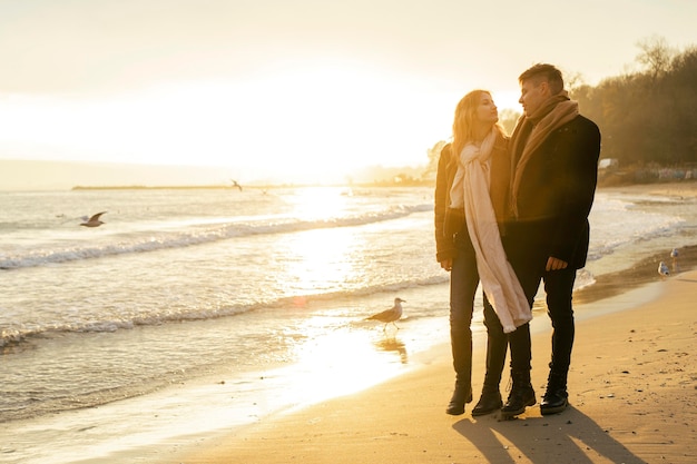 Couple marchant sur la plage ensemble en hiver