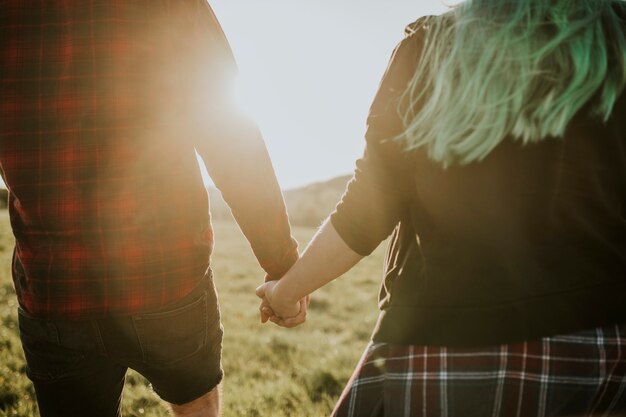 Couple marchant et se tenant la main à l'extérieur